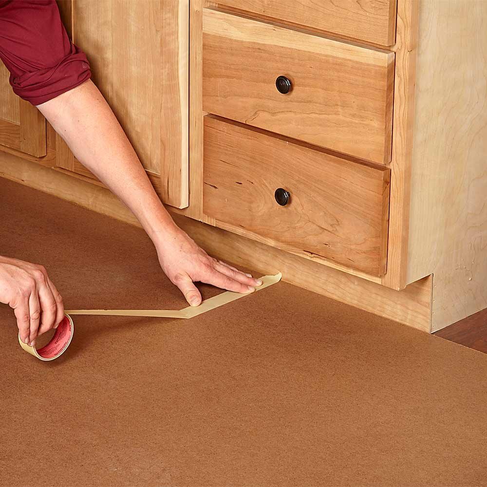Laying down sheets of hardwood to protect floors | Construction Pro Tips