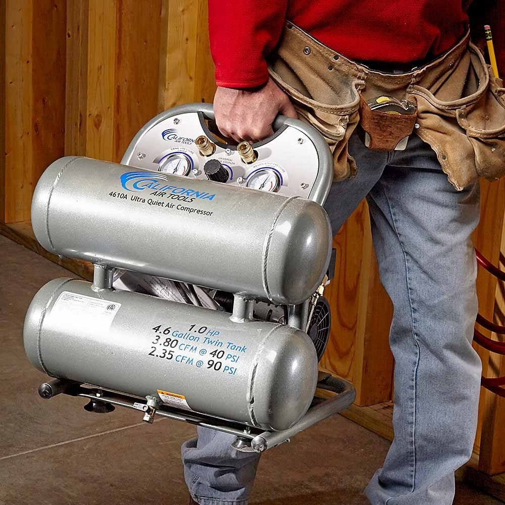 A man carrying an air compressor | Construction Pro Tips
