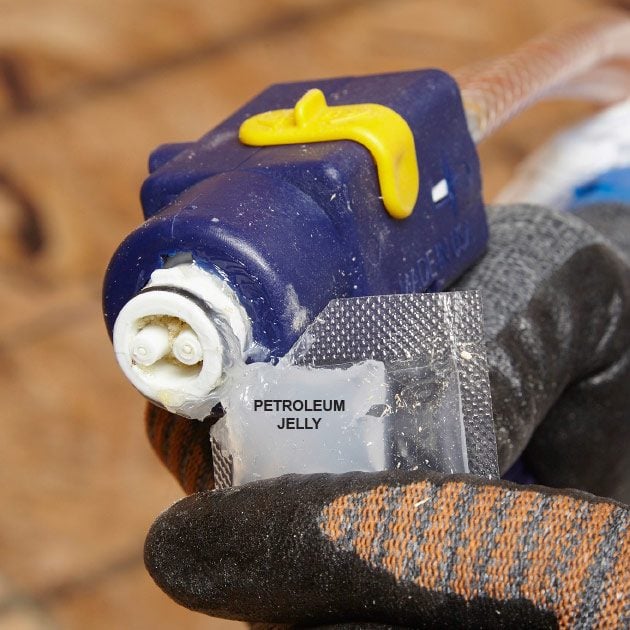 Squeezing petroleum jelly onto gun tip | Construction Pro Tips