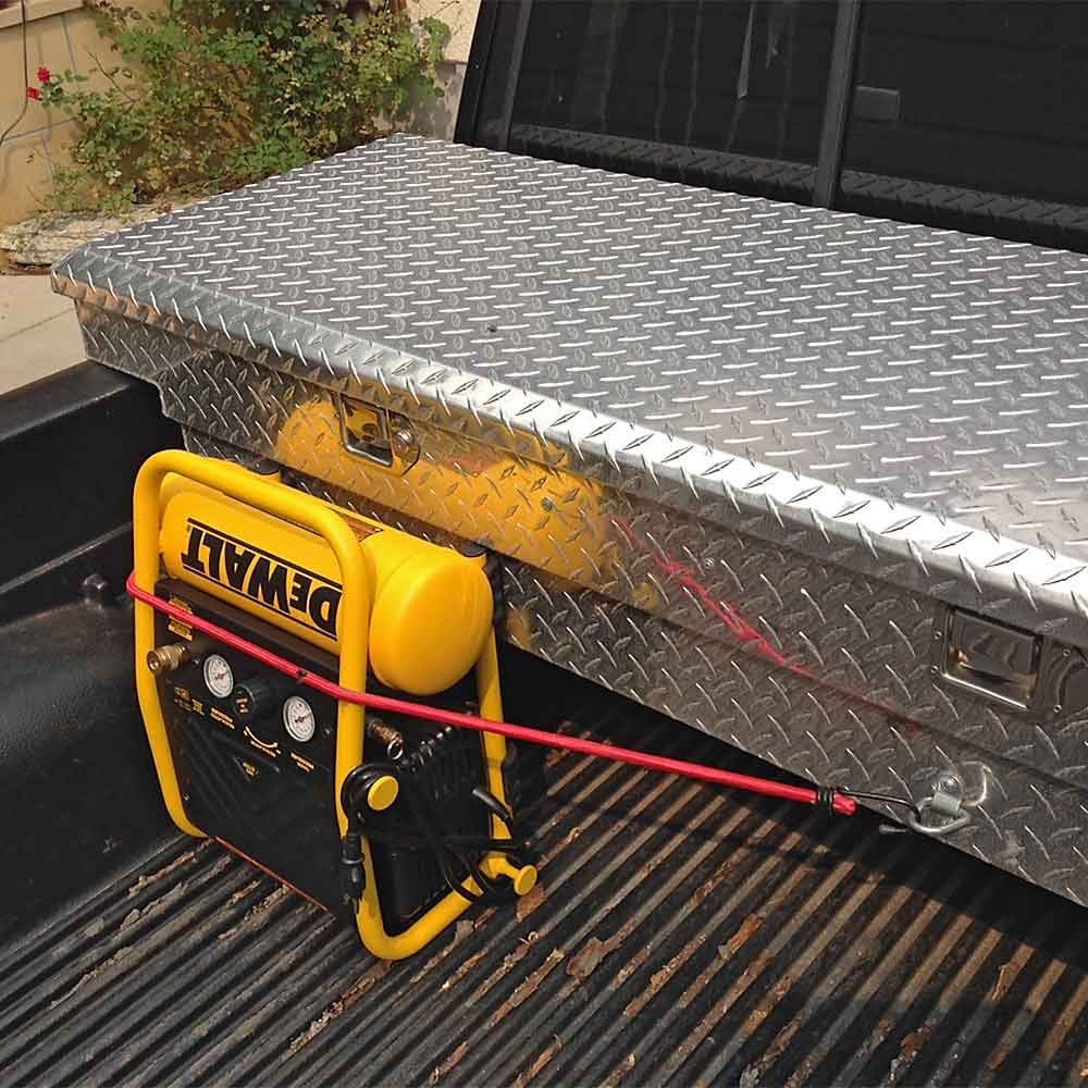 An air compressor strapped to a truck using multiple strapping locations | Construction Pro Tips