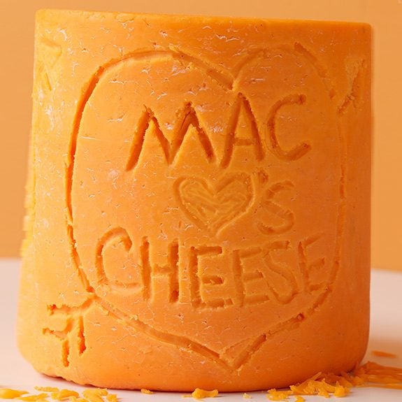 Block of cheddar cheese with Mac Hearts Cheesecarved into it