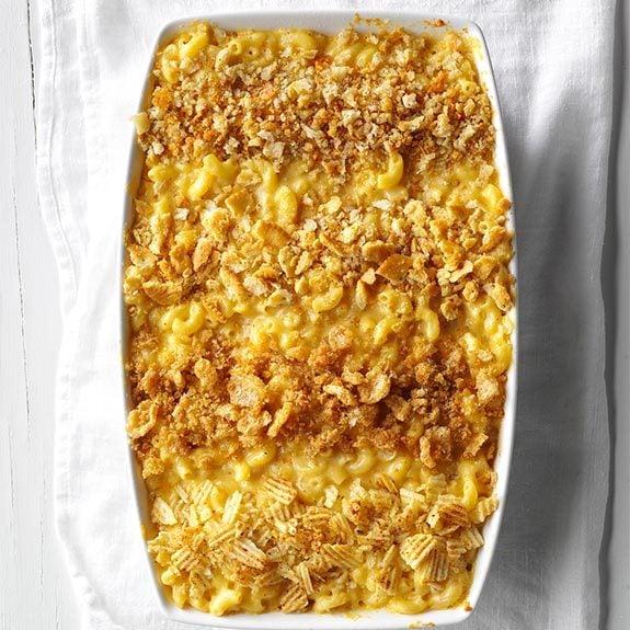 Pan of mac and cheese topped with bread crumbs, crushed Ritz crackers, crushed pork rinds and crushed potato chips.