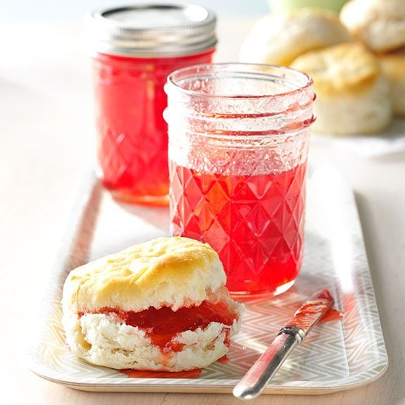Fresh strawberry freezer jam spread on a homemade biscuit