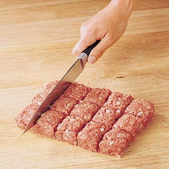 Shaping meat mixture into a rectangle to cut into uniform squares for meatballs.