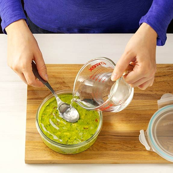 Use a spoon to flatten surface of guacamole, then cover with water to prevent browning.
